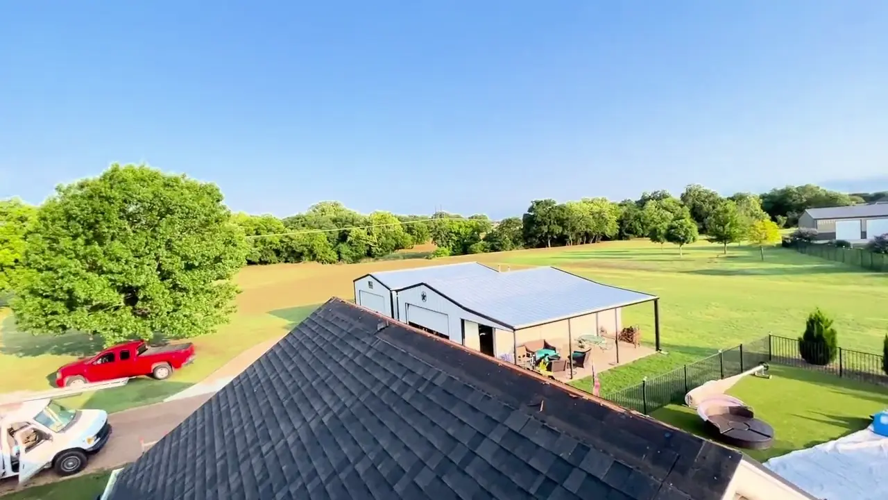 Aerial view across a completed dark shingle roof in North Texas